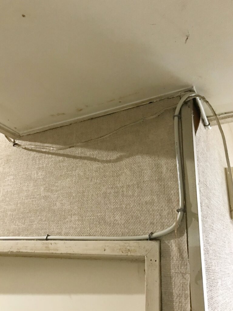 垂れている配線を壁に沿わせ、綺麗にまとめていきます。