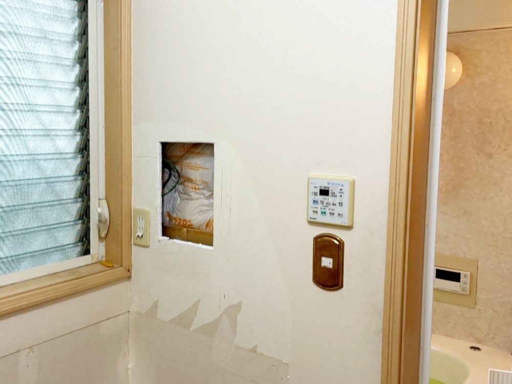 洗濯水栓を取り付けるために、壁を加工しています。