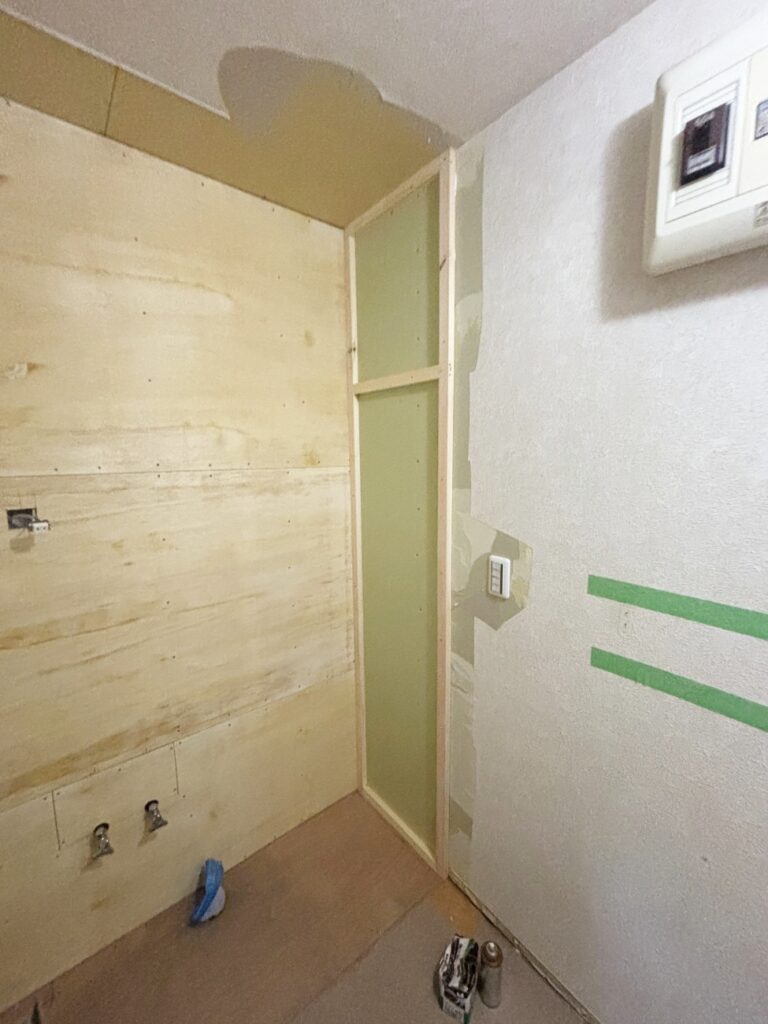 洗面台と壁の間を隙間なく納めるために、下地を作成しています。