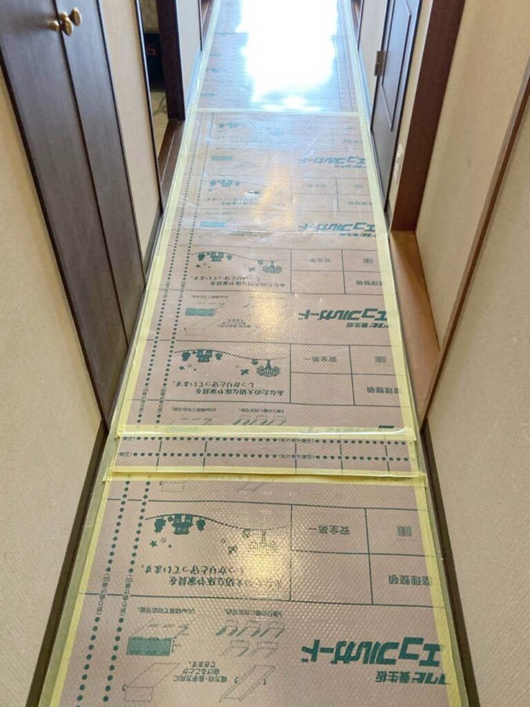 廊下の汚れ・傷防止のため、養生をしています。