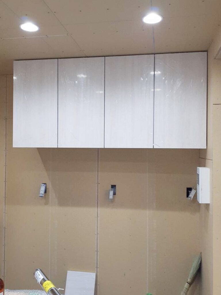 背面収納の吊り戸を取り付けています。